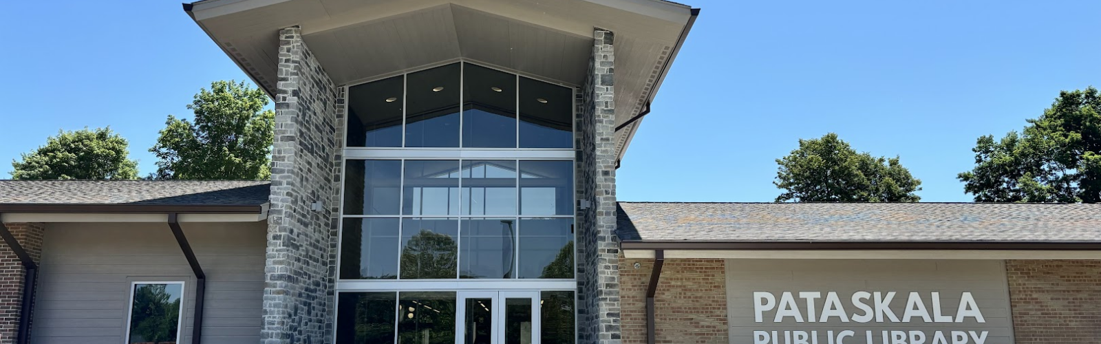 West exterior of the library against a clear sky, focused on the front door